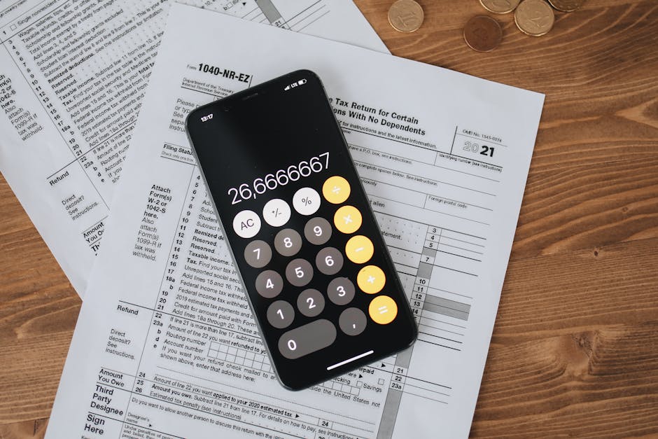 Overhead view of smartphone calculator on tax forms for finance and accounting