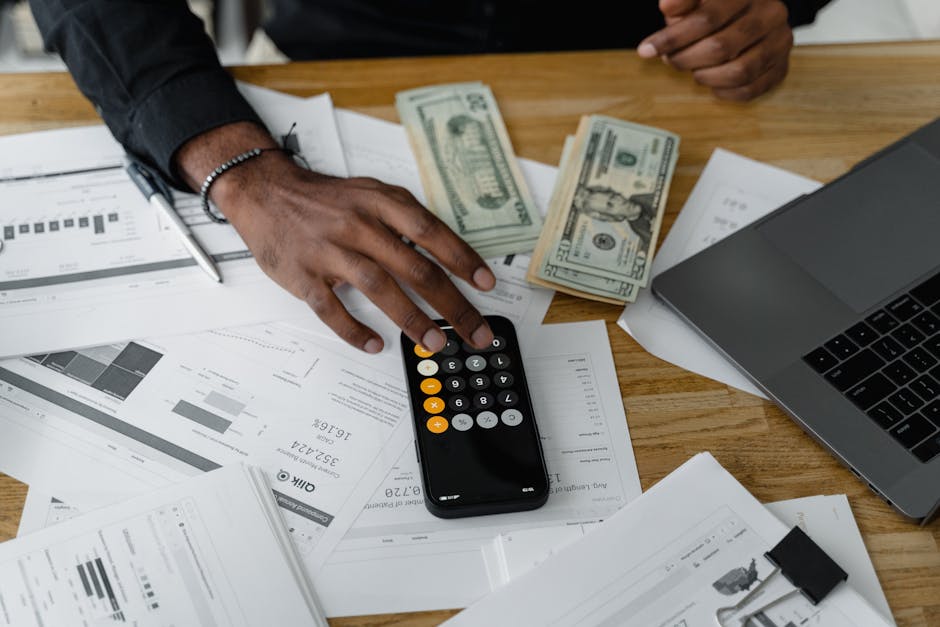 Overhead view of financial documents with calculator, cash, and laptop for financial planning